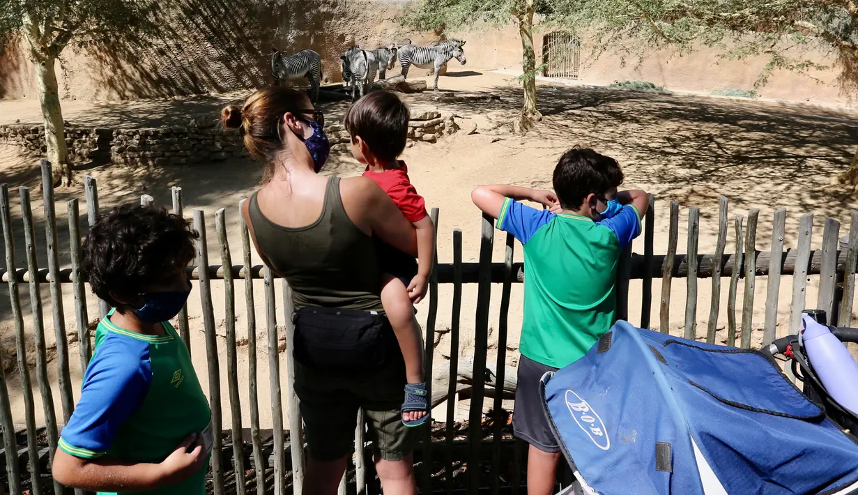 Para pengunjung melihat zebra di Kebun Binatang Los Angeles, Amerika Serikat (AS), pada 26 Agustus 2020. Kebun binatang tersebut dibuka kembali untuk umum dengan menerapkan langkah-langkah pencegahan kesehatan setelah ditutup selama 166 hari akibat pandemi COVID-19 yang masih merebak. (Xinhua)