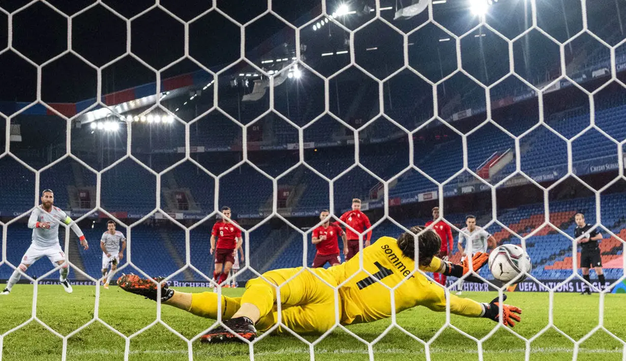 Kiper Swiss, Yann Sommer, berhasil menggagalkan tendangan penalti Sergio Ramos pada laga UEFA Nations League di Stadion St. Jakob-Park, Minggu (15/11/2020). Kedua tim bermain imbang 1-1. (Alessandro della Valle/Keystone via AP)