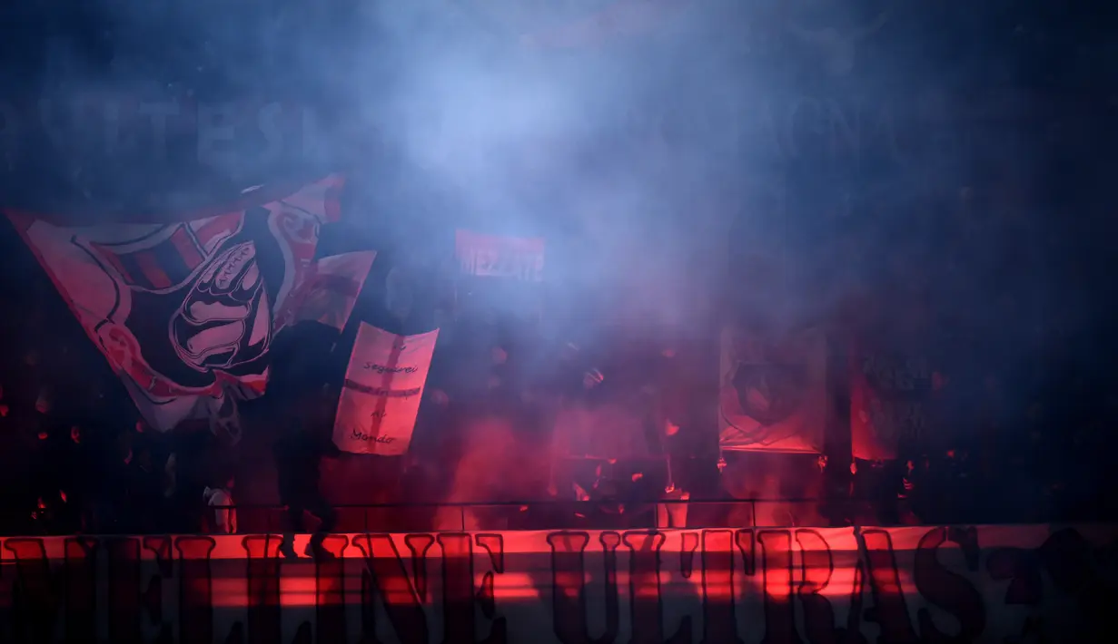 Suporter AC Milan menyalakan flare untuk merayakan kemenangan timnya atas Cagliari pada lanjutan Serie A di San Siro stadium, Milan (8/1/2017). AC Milan menang 1-0.  (AFP/Filippo Monteforte)