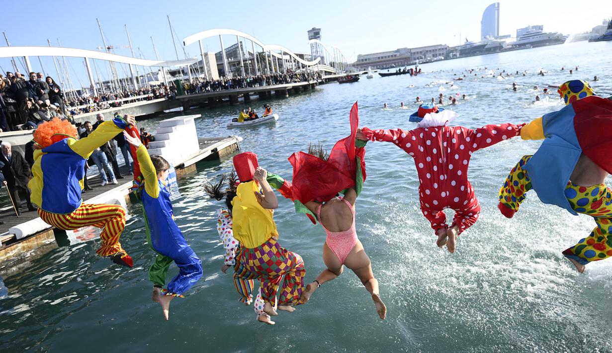 Sejumlah peserta mengenakan kostum unik melompat ke dalam air dalam perlombaan renang bertajuk Copa Nadal (Piala Natal) edisi ke-115 yang berlangsung di Port Vell, Barcelona, Spanyol, Rabu (25/12/2024). Ajang tersebut diikuti oleh 450 peserta dengan jarak renang sejauh 200 meter. (AFP/Josep Lago)