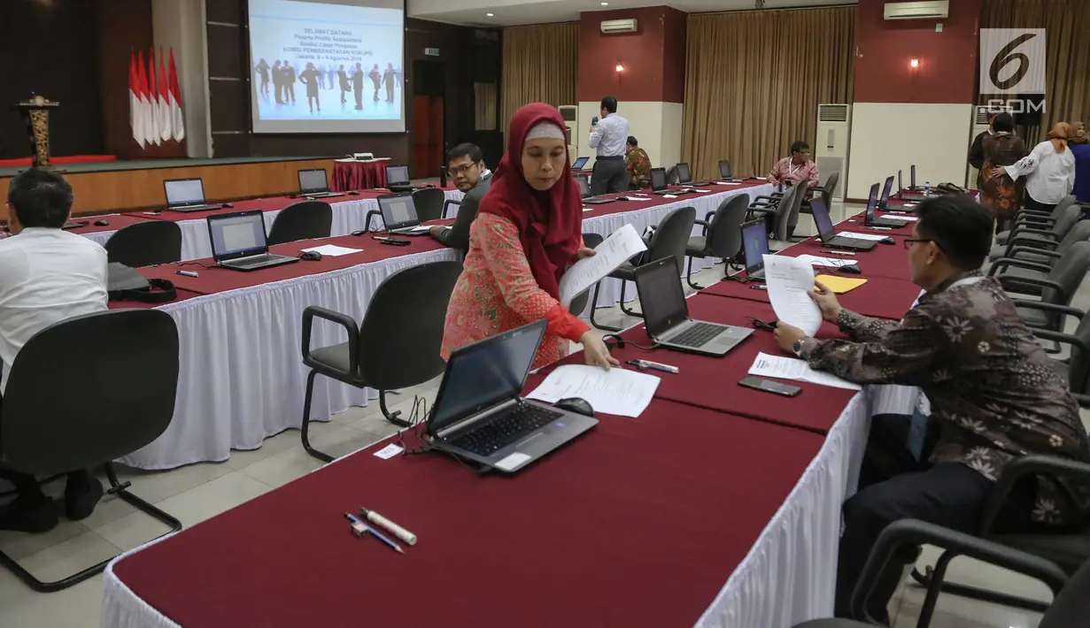 Petugas menyiapkan peralatan untuk peserta calon pimpinan (capim) KPK mengikuti tes profile assessment di Gedung Lemhanas, Jakarta, Kamis (8/8/2019). Sebanyak 40 orang capim KPK menjalani tes profile assessment selama dua hari yakni 8-9 Agustus 2019. (Liputan6.com/Faizal Fanani)
