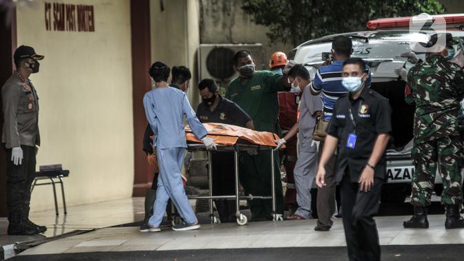 Tim forensik menurunkan kantong jenazah berisi serpihan Sriwijaya Air SJ 182 dan diduga tubuh korban dari ambulans di RS Polri, Jakarta, Minggu (10/1/2021). RS Polri menerima tiga kantong jenazah berisi serpihan pesawat dan diduga tubuh korban untuk diidentifikasi. (merdeka.com/Iqbal S. Nugroho)