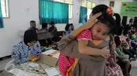 Seorang anak anggota TNI digendong ibunya usai mengikuti vaksinasi ulang di Kantor Kesehatan Kopassus Jakarta, Senin (18/7). Kopassus menggelar vaksinasi ulang terhadap anak prajurit yang terindikasi menjadi korban vaksin palsu (Liputan6.com/Helmi Afandi)