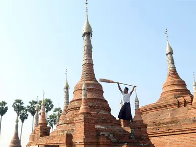 Relawan menyapu pagoda Buddha kuno di Naypyitaw, Myanmar (27/1). Pagoda yang berada di ibu kota negara tersebut dibangun 160 tahun lalu pada masa dinasti Konbaung dan Amarapura. (AP Photo/Aung Shine Oo)