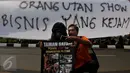 Warga berselfie dengan salah satu peserta aksi stop eksploitasi satwa yang memakai topeng orang utan sambil membawa poster di depan Kementrian Lingkungan Hidup dan Kehutanan (LHK), Jakarta, Jumat (2/10). (Liputan6.com/Johan Tallo)