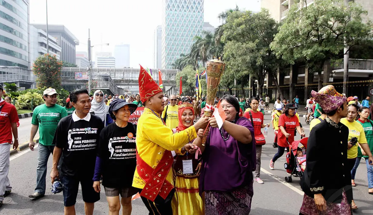 Dalam aksinya, mereka membawa obor perdamaian untuk memperingati Hari Toleransi Internasional, Jakarta, Minggu (16/11/2014). (Liputan6.com/Faizal Fanani)