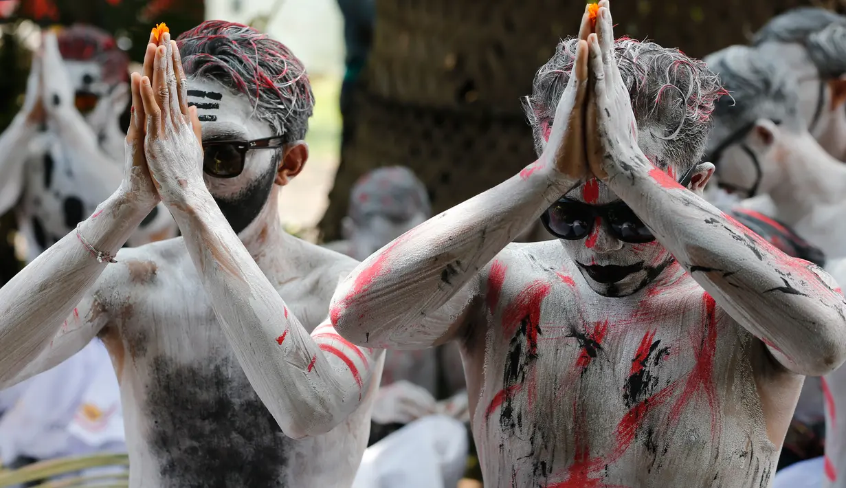 Pemuda Bali dengan cat tubuh berwarna-warni selama ritual Grebeg di Desa Tegallalang, Rabu (30/1). Dalam ritual dua tahunan ini, para pemuda berkeliling kampung dengan riasan tubuh warna-warni untuk menangkal Roh jahat. (AP/Firdia Lisnawati)