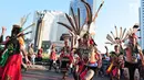 Sejumlah orang mengenakan pakaian adat menari saat pawai festival Budaya Borneo di Car Free Day, Jakarta, Minggu (30/7). Festival tersebut dalam rangka mengenalkan adat dan budaya borneo melalui pakaian dan musiknya. (Liputan6.com/Helmi Afandi)