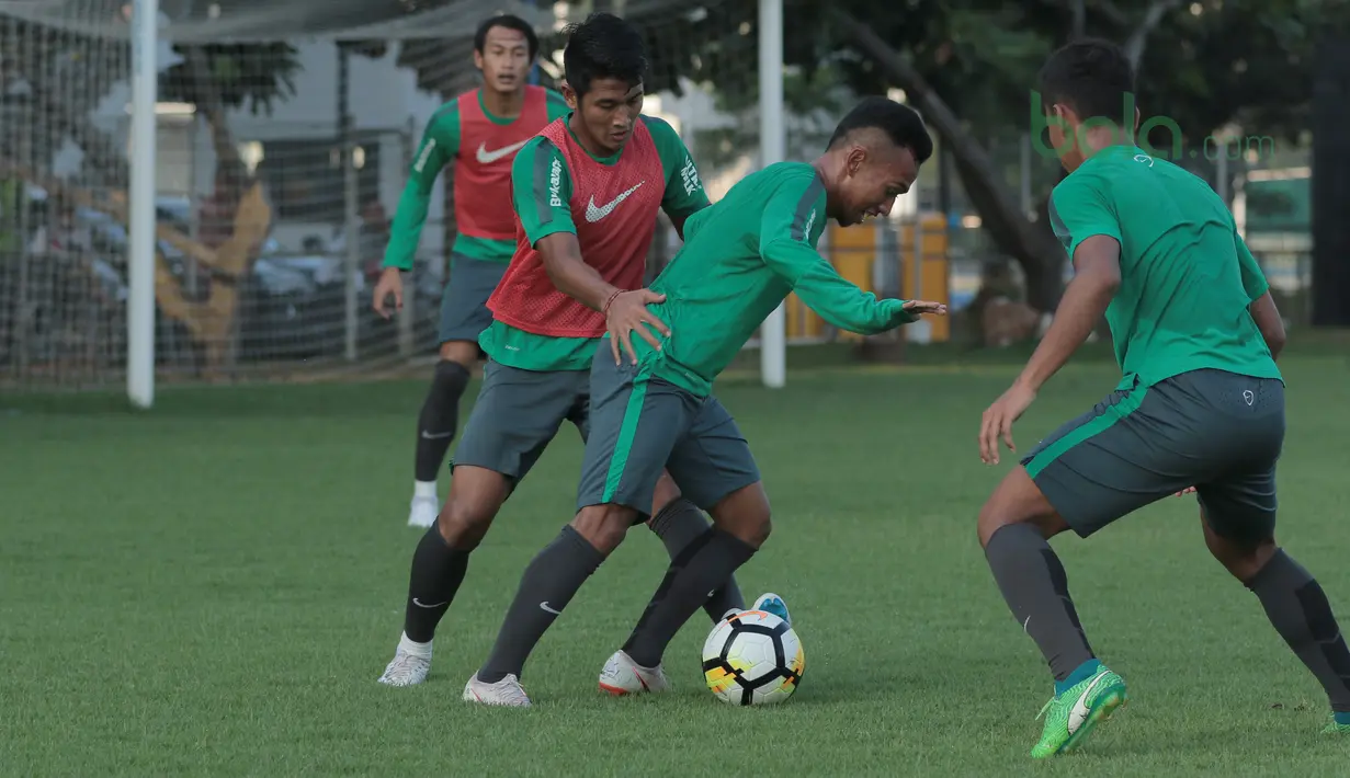 Aksi Irfan Jaya (tengah) melewati rekannya pada sesi latihan di Lapangan ABC Senayan, Jakarta (22/6/2018). Timnas melakukan persiapan untuk melawan Korea pada laga uji coba 23 Juni 2018. (Bola.com/Nick Hanoatubun)