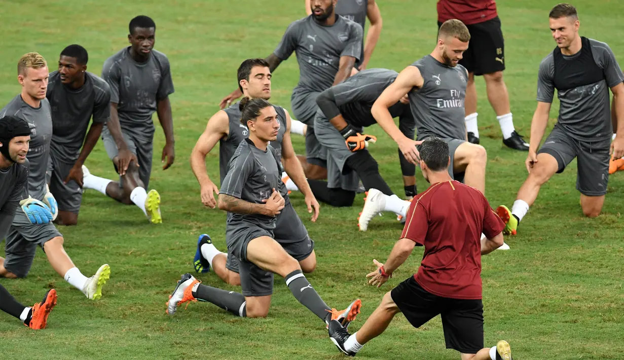 Para pemain Arsenal melakukan pemanasan saat mengikuti sesi latihan tim di Singapura (27/7). Arsenal akan bertanding melawan PSG pada International Champions Cup 28 Juli. (AFP Photo/Roslan Rahman)