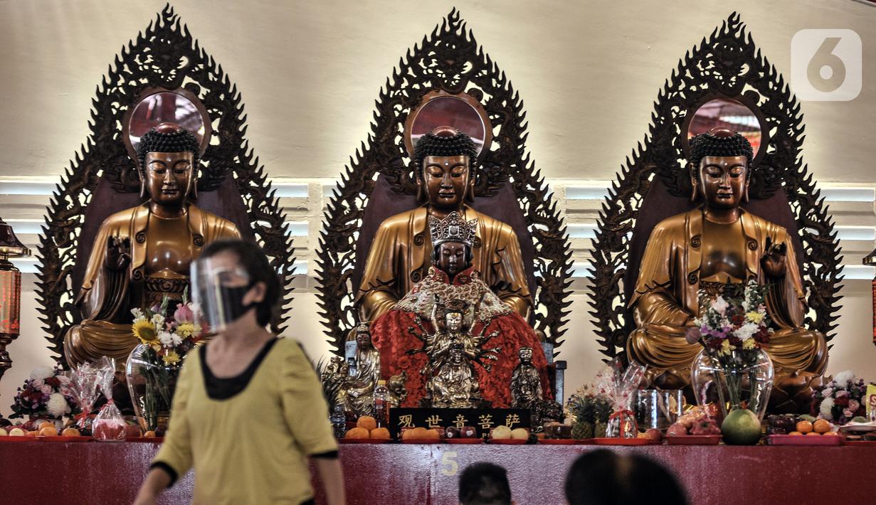 Warga keturunan Tionghoa mengenakan faceshield dan masker saat sembahyang malam Tahun Baru Imlek 2572 di klenteng kawasan Petak Sembilan, Glodok, Jakarta, Kamis (11/2/2021). Pihak klenteng juga memberikan sistem nomor antrean pada sembahyang malam Imlek kali ini. (merdeka.com/Iqbal S. Nugroho)