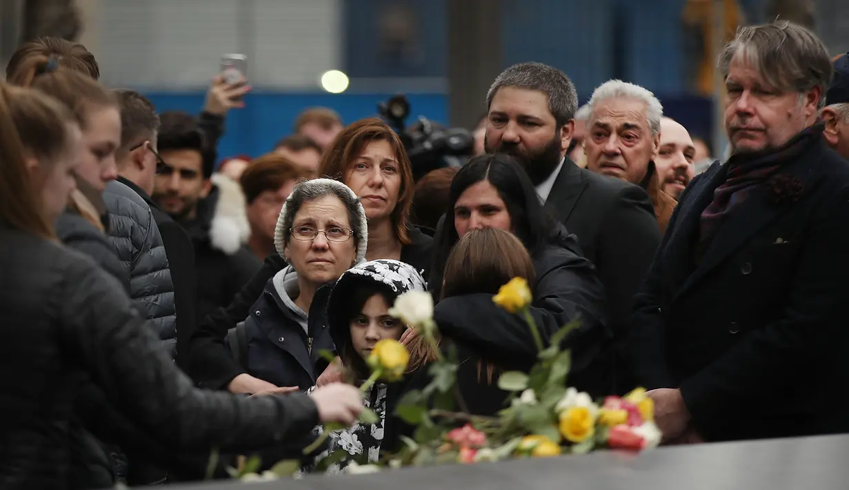Keluarga korban membawa bunga mawar dalam peringatan 25 tahun serangan bom truk di WTC, New York City, Amerika Serikat, Senin (26/2). Dalam serangan saat itu enam orang terbunuh dan lebih dari 1.000 orang terluka. (Spencer Platt/Getty Images/AFP)