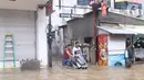 Warga mendorong motor saat banjir merendam kawasan Benhil, Jakarta, Selasa (25/2/2020). Hujan yang mengguyur wilayah tersebut membuat air sungai meluap sehingga menyebabkan Banjir setinggi pinggang orang dewasa. (Liputan6.com/Angga Yuniar)