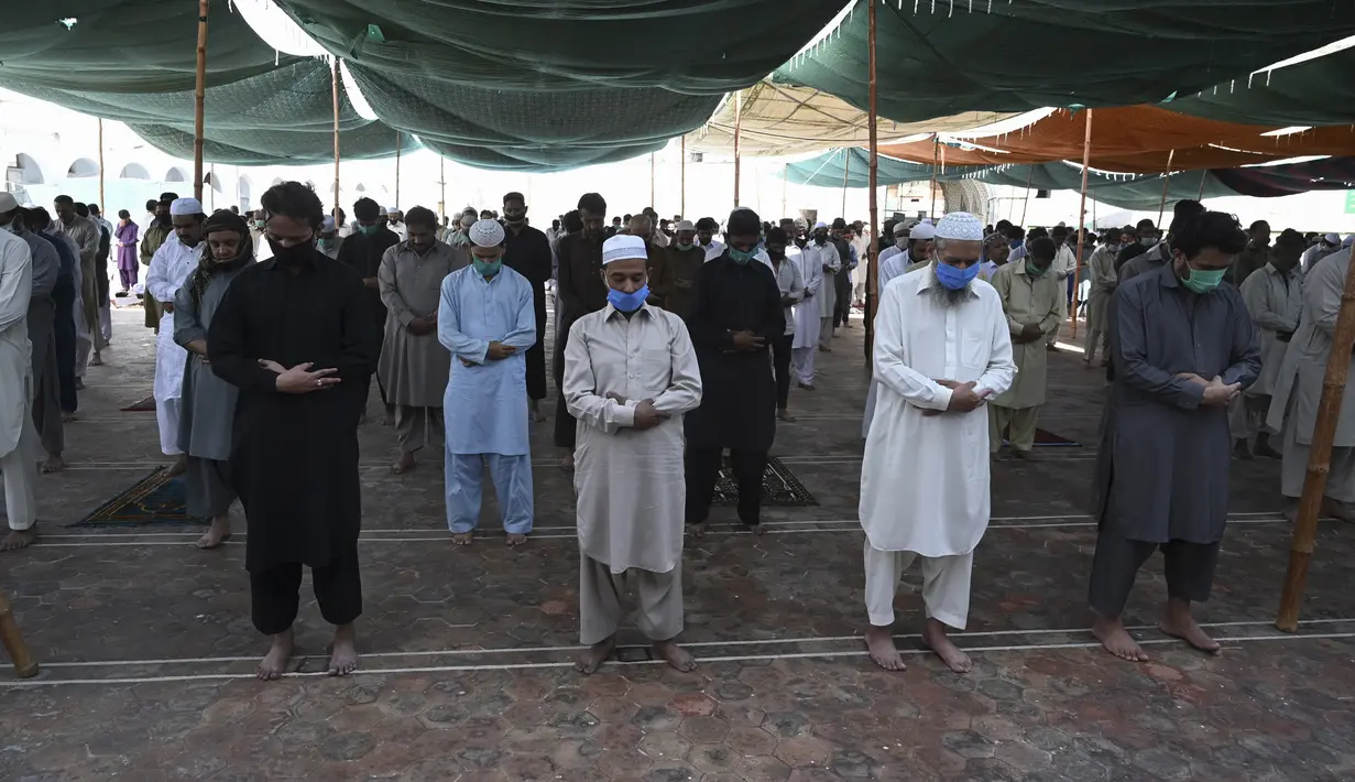 Umat muslim mengenakan masker saat melaksanakan salat Jumat berjemaah selama Ramadan di Masjid Jamia, Rawalpindi, Jumat (1/5/2020). Umat muslim dunia melaksanakan Ramadan tahun ini di tengah pandemi COVID-19. (Aamir QURESHI/AFP)