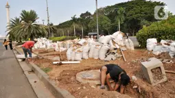 Pekerja menyelesaikan pembuatan sumur resapan di kawasan Monas, Kamis (21/11/2019). Sudin Perindustrian dan Energi Kota Administrasi Jakpus membuat sekitar 70 titik sumur resapan di taman kawasan Monas guna meminimalisir genangan sekaligus menampung air saat hujan. (merdeka.com/Iqbal Nugroho)