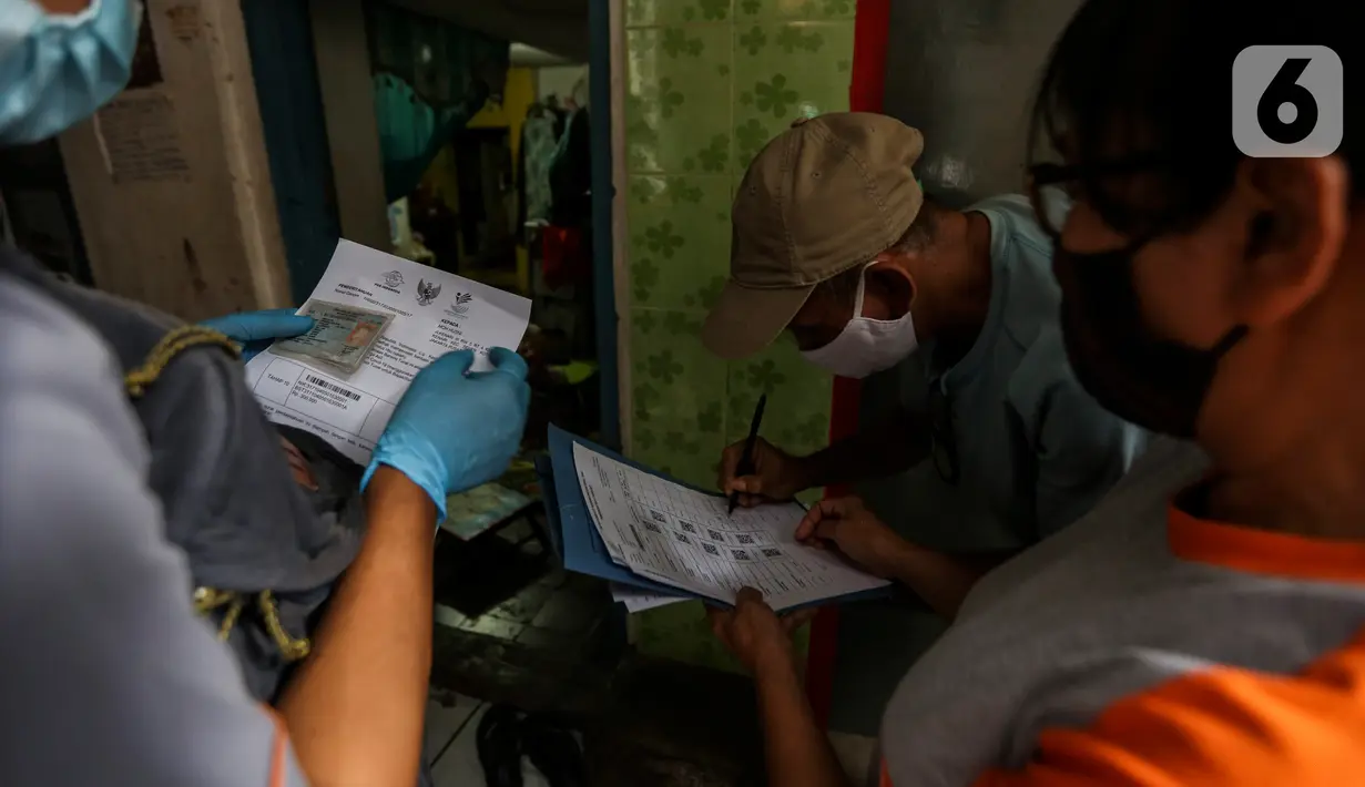 Warga penerima bantuan menandatangani bukti pemberian bantuan sosial tunai (BST) di RW 05 Kelurahan Kenari, Senen, Jakarta, Rabu (6/1/2021). Pencairan bantuan senilai Rp 300 ribu dilakukan dengan tiga cara, salah satunya diantar langsung ke rumah secara door to door. (Liputan6.com/Johan Tallo)