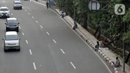 Penyandang Masalah Kesejahteraan Sosial (PMKS) menunggu warga memberikan sedekah di pinggir jalan, Jakarta, Rabu (13/5/2020). Sejumlah PMKS menantikan sedekah berupa uang, makanan, hingga sembako dari pengendara yang melintas. (merdeka.com/Iqbal S. Nugroho)