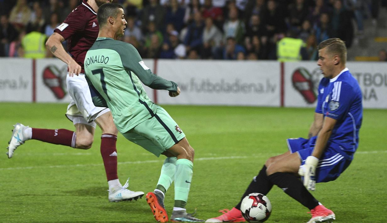 Bintang Portugal, Cristiano Ronaldo, berusaha membobol gawang Latvia pada laga kualifikasi Piala Dunia 2018 di Stadion Skonto, Riga, Jumat (9/6/2017). Latvia kalah 0-3 dari Portugal. (AP/Roman Koksarov)