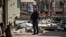 Seorang polisi Ukraina berdiri di dekat mayat yang ditutupi lembaran plastik setelah serangan roket yang digunakan untuk evakuasi sipil di sebuah stasiun kereta api di Kramatorsk, Ukraina timur (8/4/2022). (AFP/Fadel Senna)