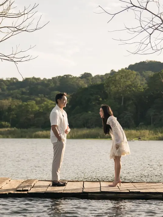 Potongan dress tersebut menonjolkan detail renda yang elegan dengan lengan balon yang mempermanis tampilannya. Pilihan busana ini sangat sesuai dengan suasana lamaran yang dilakukan di alam terbuka, memberikan nuansa sederhana tetapi penuh makna. [@jessicajane99].