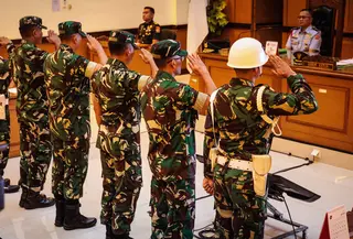 Empat personel Tentara Nasional Indonesia (TNI) yang dituduh menyiram air keras saat memberi hormat kepada seorang aktivis Hak Asasi Manusia (HAM) saat menghadiri sidang pembacaan putusan di Pengadilan Militer II-08, Jakarta pada Rabu 10 Juni 2026. (Yasuyoshi Chiba/AFP)