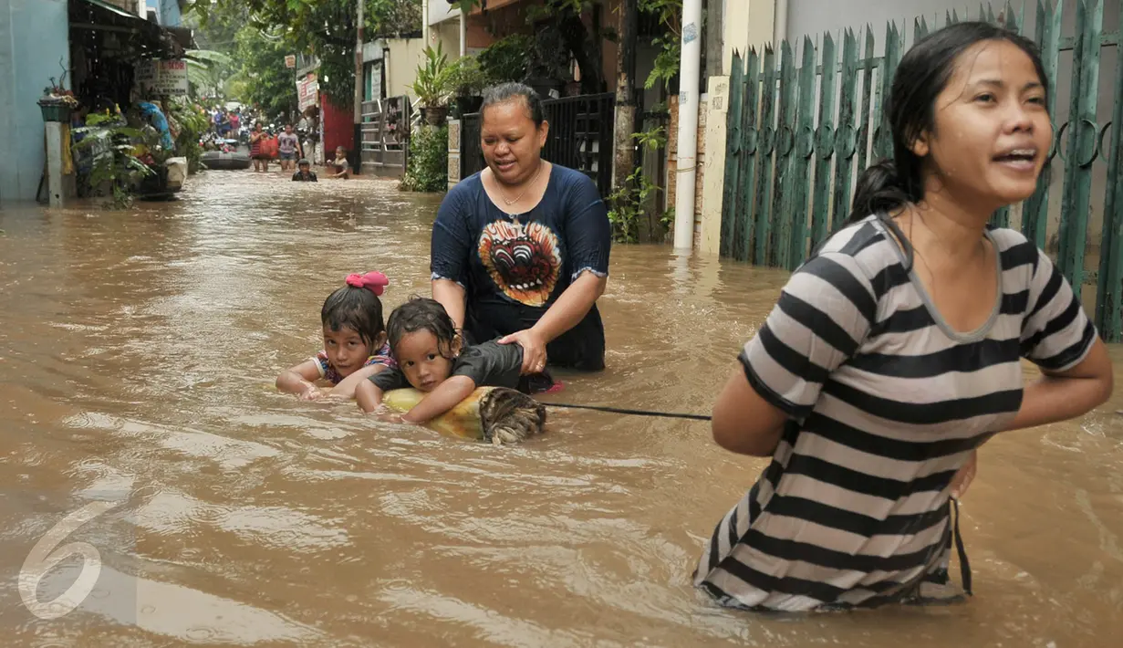 Warga melintasi banjir di kawasan Cipinang Melayu, Jakarta Timur, Senin (20/2). Banjir ini merendam RW 3 hingga RW 4, Kelurahan Cipinang Melayu, Kecamatan Cipinang Muara. (Liputan6.com/Yoppy Renato)