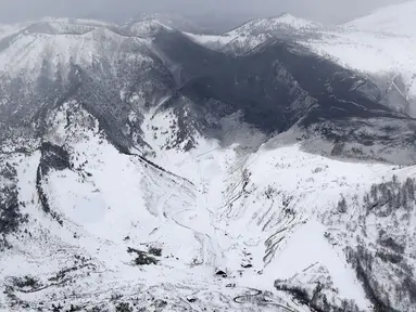 Gumpalan abu vulkanik akibat letusan menutupi puncak Gunung Kusatsu-Shirane di Kusatsu, Prefektur Gunma, Jepang, Selasa (23/1). Letusan mengakibatkan longsoran salju dan menerjang resor ski. (Suo Takekuma/Kyodo via AP)