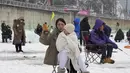 Seorang wanita melemparkan tali melalui lubang yang dibor di permukaan sungai beku selama kontes menangkap ikan trout di Hwacheon, Korea Selatan, Sabtu (7/1/2023). Kontes ini merupakan bagian dari festival es tahunan yang menarik lebih dari satu juta pengunjung setiap tahun. (AP Photo/Ahn Young-joon)