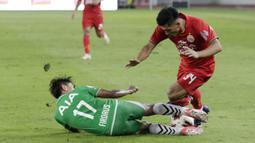 Penyerang Persija Jakarta, Heri Susanto, terjatuh saat berebut bola dengan pemain Geylang International FC, Firdaus Kasman, pada laga uji coba di SUGBK, Jakarta, Minggu, (23/2/2020). Persija menang dengan skor 3-1. (Bola.com/M Iqbal Ichsan)