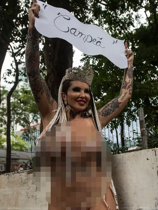 Penari Samba, Boing Boing dari sekolah Samba Tautape memegang poster yang bertuliskan "Juara" sambil keliling Jalan Paulista di Sao Paulo, Brasil (2/3). (AFP Photo / Nelson Almeida) 