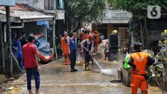 Personel dari Dinas Penanggulangan Kebakaran dan Penyelamatan (Gulkarmat) Provinsi DK Jakarta menyemprotkan air untuk membersihkan endapan sisa lumpur di permukiman warga di kawasan Rawajati, Kalibata, Jakarta Selatan, Jakarta, Rabu (5/3/2025). (Liputan6.com/Angga Yuniar)