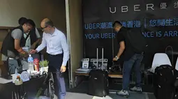 Polisi Hong Kong melakukan razia di kantor jasa pelayanan taxi Uber Inc, Selasa (11/8/2015). Polisi berhasil mengamankan 5 orang yang tertangkap basah memberikan jasa pelayanan sebagai sopir taxi dengan kendaraan ilegal. (REUTERS/Apple Daily)