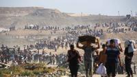 Orang-orang berjalan membawa tas-tas berisi bantuan kemanusiaan yang mereka terima di pusat distribusi yang dikelola oleh Yayasan Kemanusiaan Gaza (GHF) yang didukung Ameriks Serikat dan Israel, di koridor Netzarim, Nuseirat, Jalur Gaza tengah, pada 26 September 2025. (Eyad BABA/AFP)