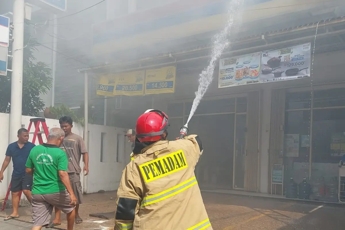 Pemadam kebakaran tengah memadamkan api yang melalap Indomaret di di Jalan Kramat 4 Senen, Jakarta Pusat.
