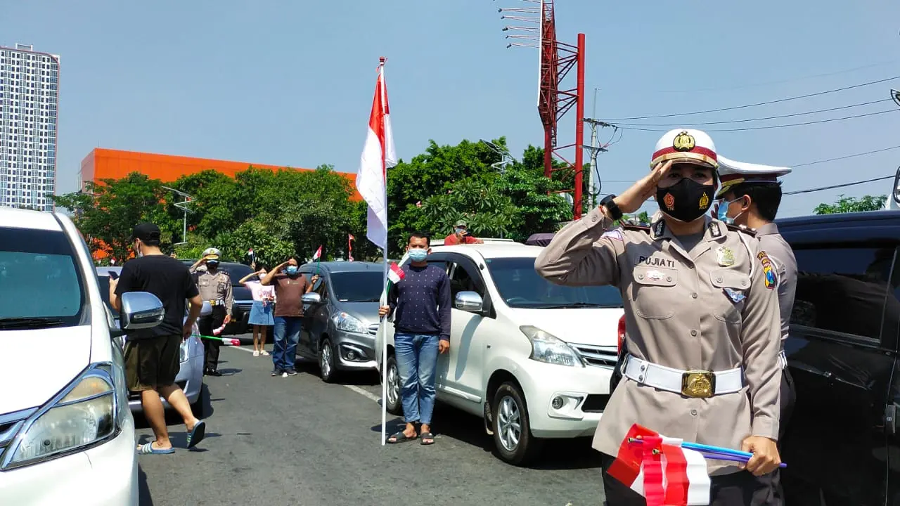 Pengendara di Surabaya menyanyikan lagu Indonesia Raya menyambut HUT RI. (Dian Kurniawan/Liputan6.com)