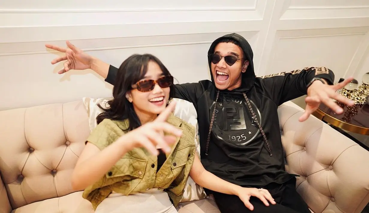 Dalam foto ini, terlihat keduanya mengenakan busana yang serasi. Fuji dengan double breasted waistcoat berkerah dengan nuansaa hijau, sedangkan Fadly tampak mengenakan hoodie hitam. Keduanya juga kompak mengenakan sunglasses. Foto: Instagram.