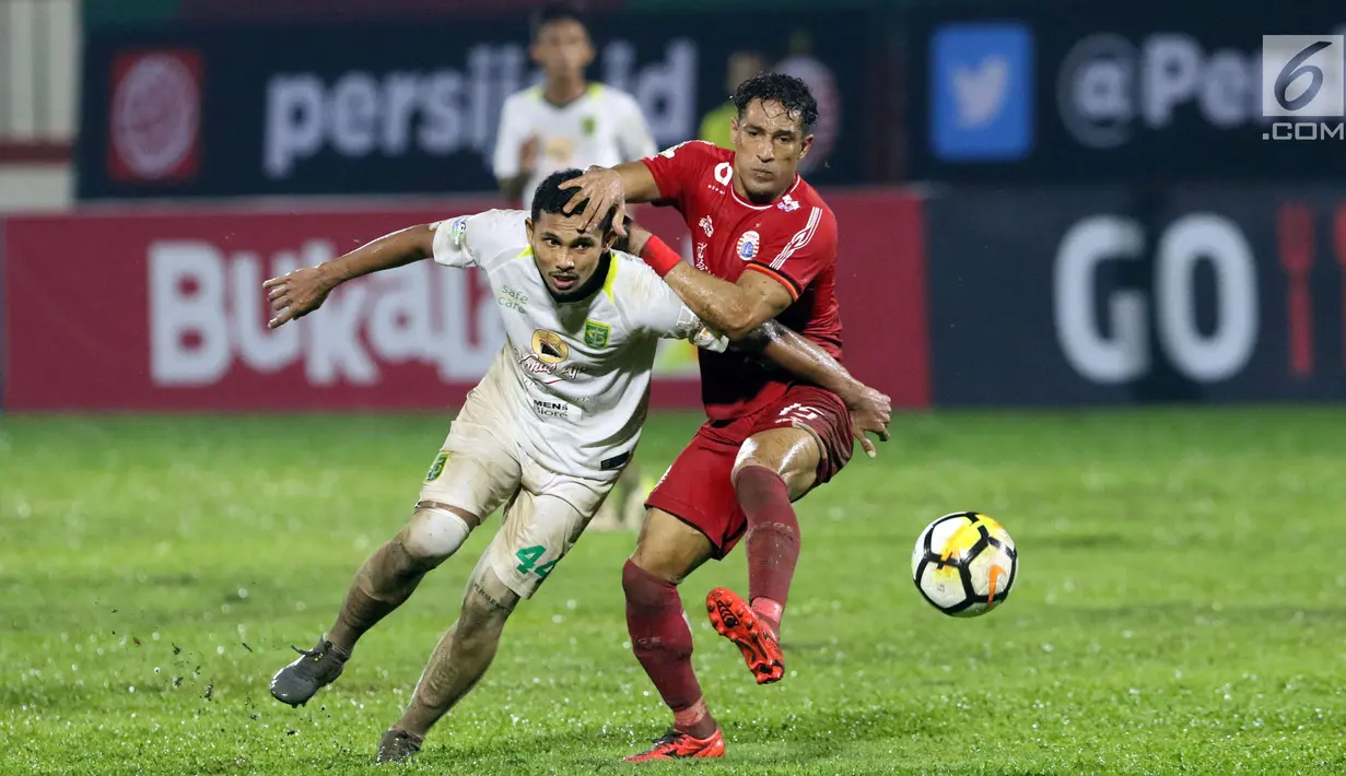 Pemain depan Persija, Addison Alves (kanan) berebut bola dengan Andri Muladi (Persebaya) pada lanjutan Go-Jek Liga 1 Indonesia 2018 bersama Bukalapak di Lapangan PTIK Jakarta, Selasa (26/6). Laga berakhir imbang. (Liputan6.com/Helmi Fithriansyah)