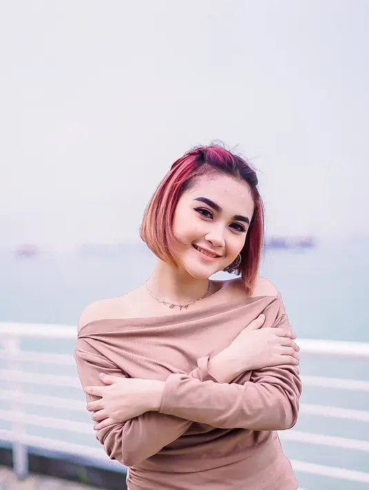 Arlida juga pernah mewarnai rambutnya dengan warna merah ombre. Masih dengan gaya rambut bob, ia terlihat sangat cantik. Ia tampak tersebyum saat berpose dengan pakaian berwarna cokelat muda dan latar belakang laut. (Liputan6.com/IG/@arlidaputrii)