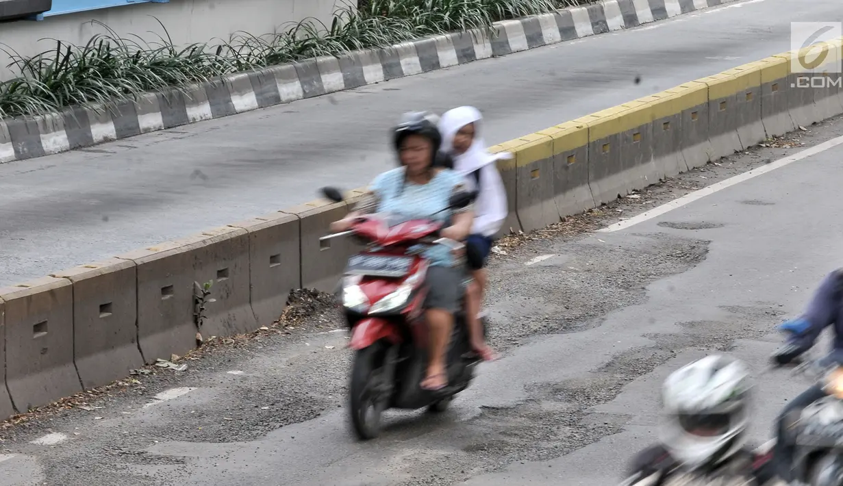 Pengendara motor melintasi jalan berlubang di Gunung Sahari, Jakarta, Selasa (29/1). Sedikitnya terdapat 8 titik jalan rusak dan berlubang di sepanjang Jalan Gunung Sahari berdiameter hingga 10 cm dengan kedalaman 10 cm. (Merdeka.com/Iqbal S. Nugroho)