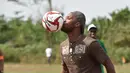 Mantan penyerang Chelsea, Didier Drogba menunjukan skil dalam mgnolah bola saat membuka sekolah dasar di Onahio, Pokou-Kouamekro, Pantai Gading, (20/1/2018).  Drogba menjadi salah satu sponsor utama untuk sekolah tersebut. (AFP/Sia Kambou)