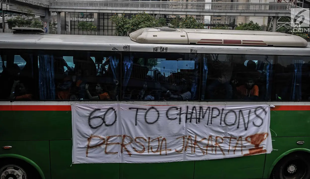 Suporter Persija berada di dalam bus melewati jalan Gatot Subroto menuju stadion Gelora Bung Karno, Jakarta, Minggu (9/12). Antusiasme ribuan suporter Persija bersiap mendukung tim kesayangannya bertanding melawan Mitra Kukar. (Liputan6.com/Faizal Fanani)
