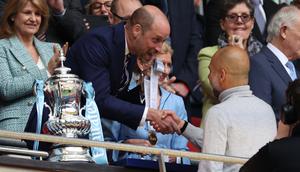Pangeran William dari Inggris berjabat tangan dengan pelatih asal Spanyol milik Manchester City, Pep Guardiola, di samping trofi Piala FA setelah pertandingan final antara Chelsea melawan Manchester City di Stadion Wembley, London, pada 16 Mei 2026. Manchester City memenangkan pertandingan dengan skor 1-0. Gelar Piala FA ketiga pada era kepelatihan Guardiola tersebut mengakhiri dua kekalahan beruntun City di partai final. (Adrian Dennis / AFP)