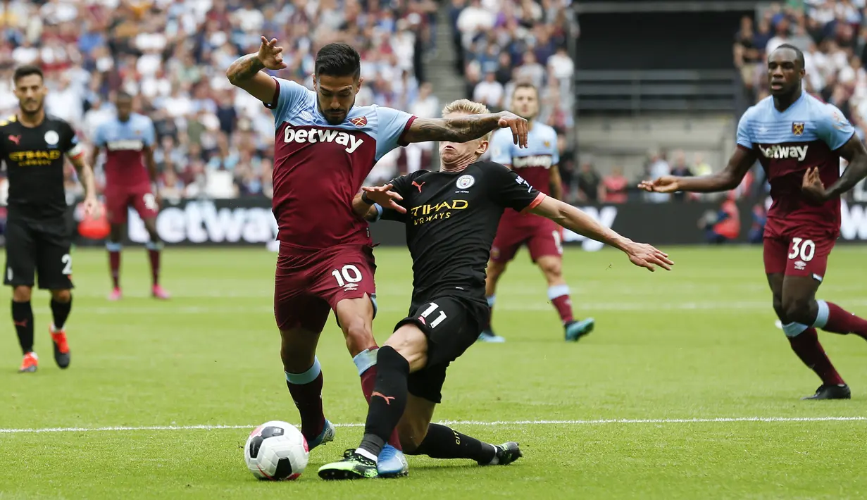 Gelandang Manchester City, Oleksandr Zinchenko, berebut bola dengan gelandang West Ham, Manuel Lanzini, pada laga Premier League di Stadion London, London, Sabtu (10/8). West Ham kalah 0-5 dari City. (AFP/Ian Kington)