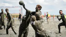 Peserta berebut bola saat bermain bola tangan di kubangan lumpur, Brunsbuettel, Jerman, (30/7).Permainan ini dikenal dengan nama "Wattoluempiade" (Olimpiade Lumpur). (REUTERS/Fabian Bimmer)