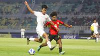Pemain Timnas Indonesia U-19, Rizdjar Nurviat (kiri) menguasai bola dibayangi pemain Timnas Timor Leste U-19, Carol Waitilia Moreira pada laga matchday ketiga Grup A Piala AFF U-19 di Stadion Gelora Bung Tomo, Surabaya. Selasa (23/7/2024). (Bola.com/Aditya Wany)
