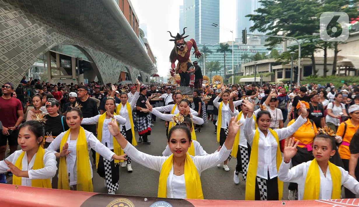 Sejumlah penari saat mengarak ogoh-ogoh saat hari bebas berkendara di kawasan Bundaran HI, Jakarta, Minggu (12/3/2023). Kegiatan ini diharapkan bisa menjadi simbol kerukunan antar umat beragama di Jakarta. (Liputan6.com/Angga Yuniar)