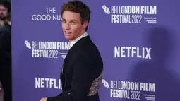 Aktor Inggris Eddie Redmayne berpose untuk fotografer saat tiba untuk pemutaran perdana film 'The Good Nurse' pada acara London Film Festival di London, Inggris, 10 Oktober 2022. Aktor berusia 40 tahun itu tampak necis dalam setelan jas hitam karya Alexander McQueen yang menampilkan payet pada bagian belakang jasnya. (Photo by Scott Garfitt/Invision/AP)