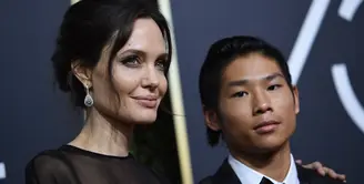 Nama Angelina Jolie tak pernah lepas dari perhatian publik. Bukan soal proses cerainya dengan Brad Pitt, kali ini Jolie hadir di Golden Globe 2018 bersama anaknya, Pax. (AFP/Valerie Macon)