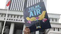 Poster "Tolak Swastanisasi Air" saat sejumlah massa menggelar  aksi menolak swastanisasi perusahaan pengelolaan air, di depan Mahkamah Agung, Jakarta, Jumat (3/6). Mereka meminta MA memutus secara adil dan bijak hak atas air. (Liputan6.com/Faizal Fanani)