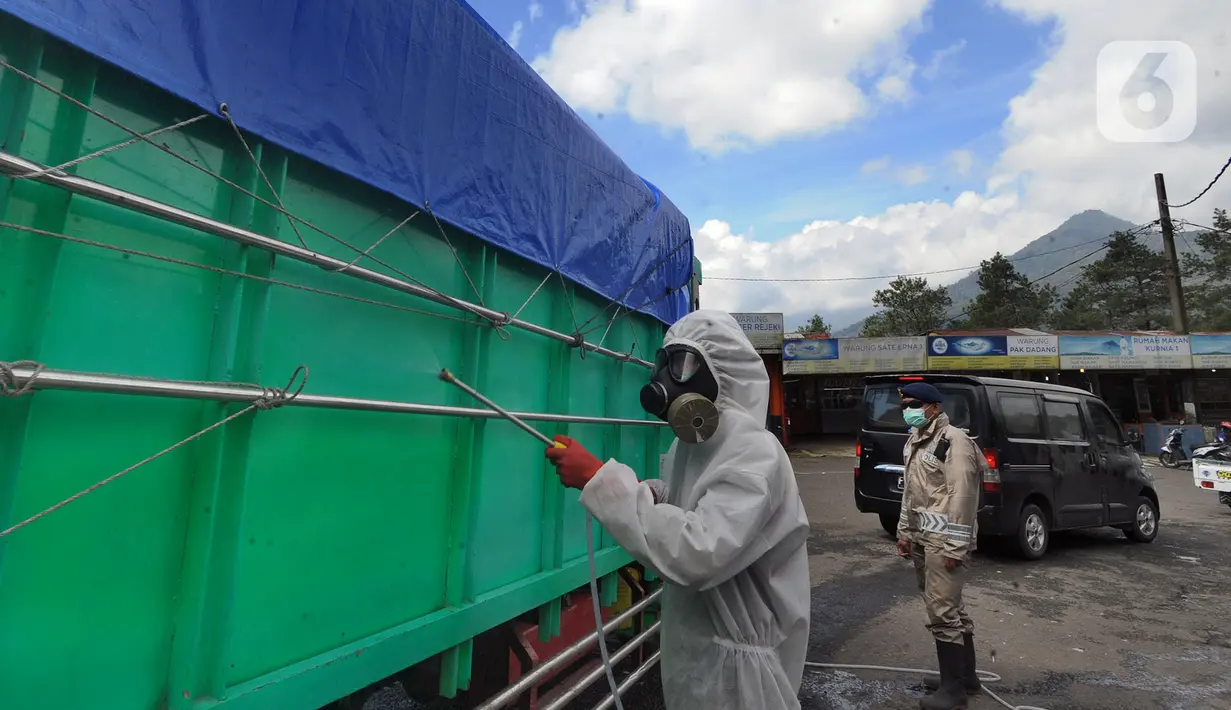 Anggota Batalyon B Brimob Cipanas melakukan penyemprotan disinfektan saat penyekatan arus lalu lintas di kawasan Ciloto, Cianjur, Jawa Barat, Jumat (17/4/2020). Penyemprotan yang dilakukan selama 20 hari tanpa henti ini untuk mencegah penyebaran virus corona COVID-19. (merdeka.com/Arie Basuki)